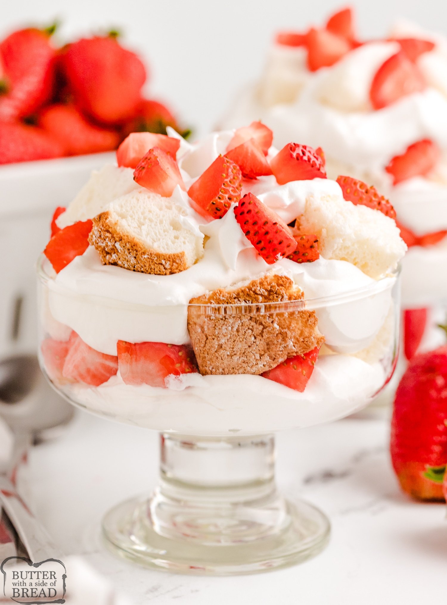 angel food cake cubed and topped with strawberries and whipped cream as parfaits
