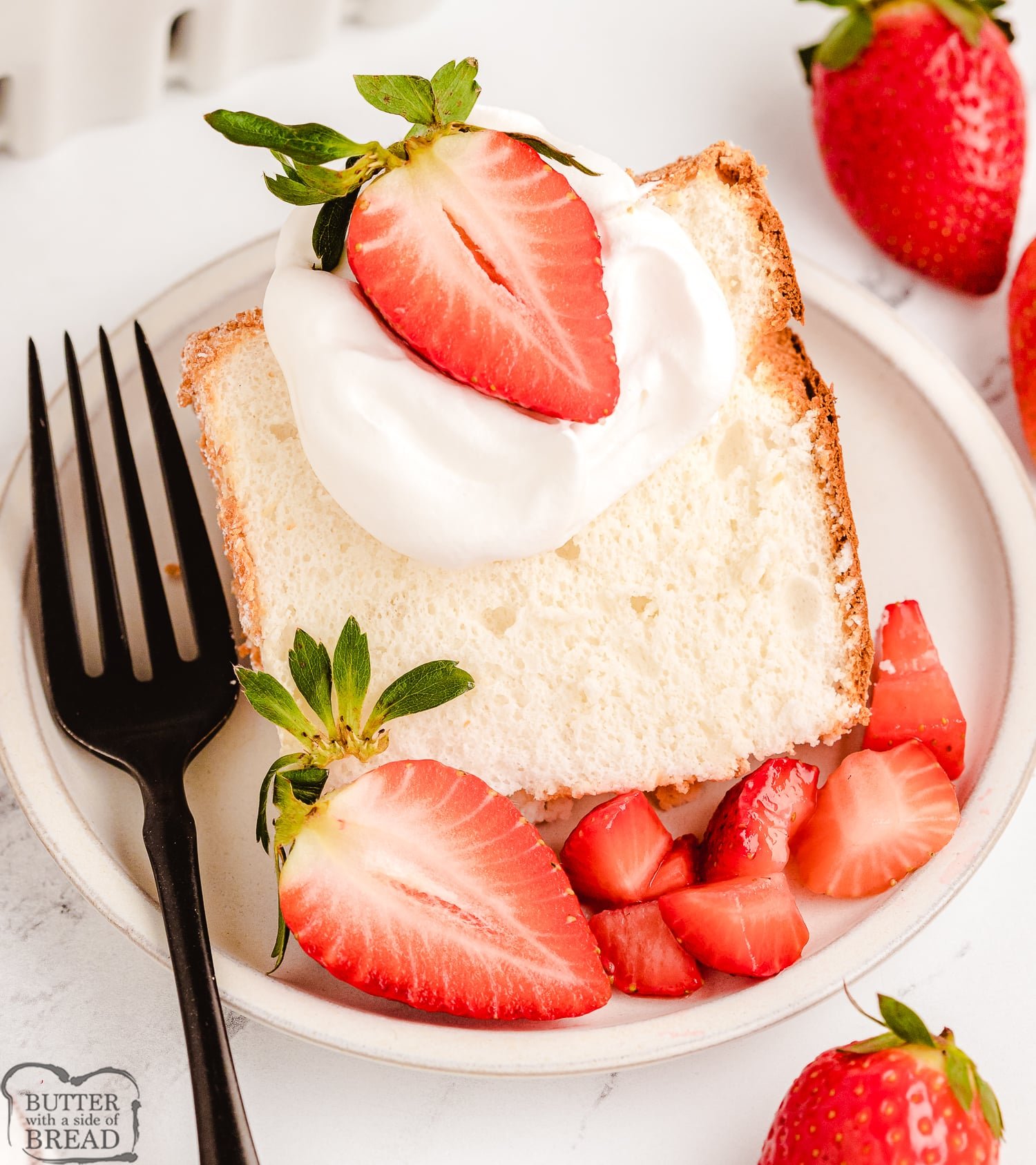 angel food cake served with strawberries and whipped cream