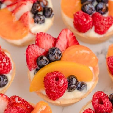 mini fresh fruit tarts topped with berries and cream