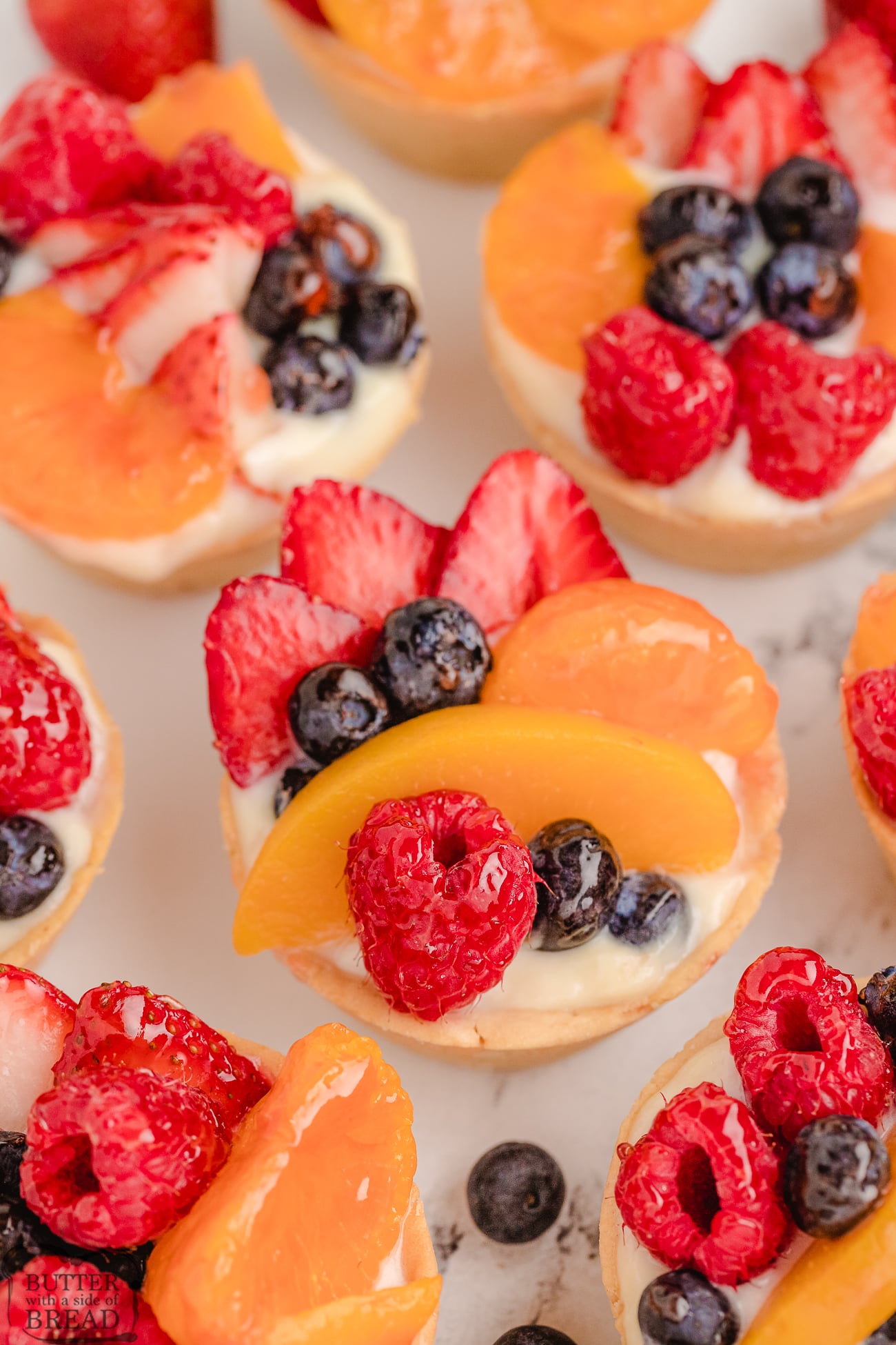 mini fresh fruit tarts topped with berries and cream