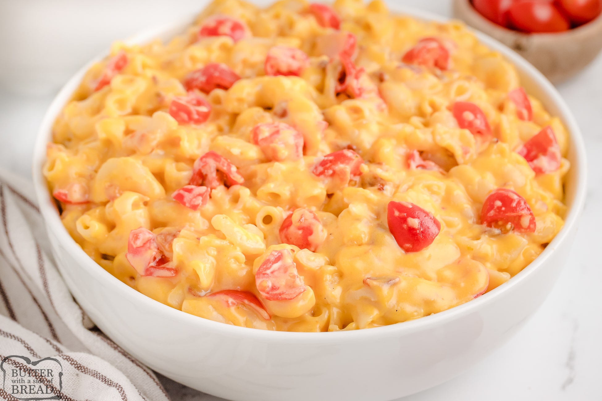 big bowl of homemade mac and cheese with tomato and bacon