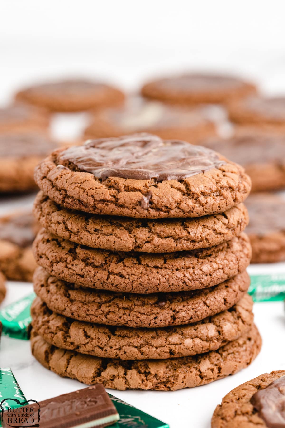 Stack of chocolate cookies with melted Andes mints on top. 