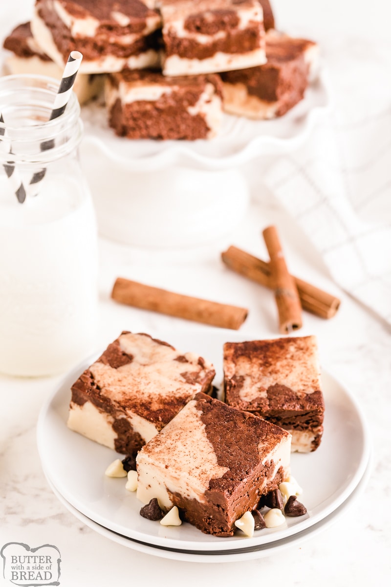 cinnamon marble fudge squares on a white plate with cinnamon sticks
