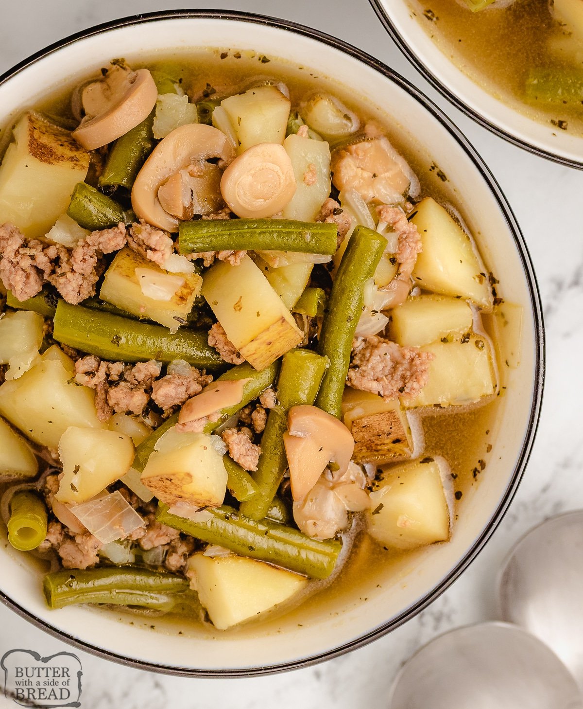 bowl of german sausage soup with potatoes and green beans