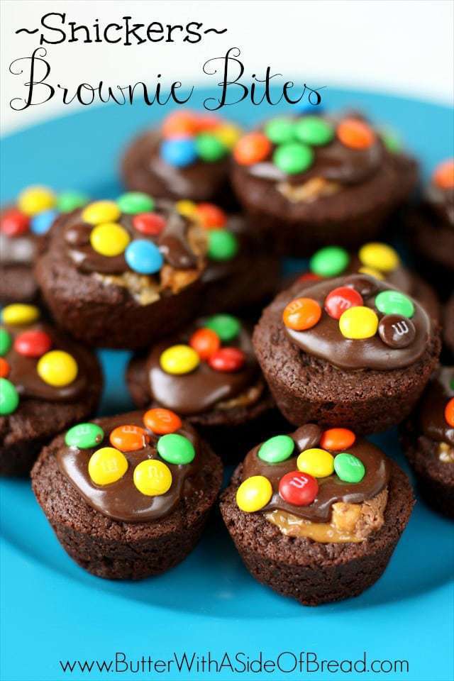 Snickers Brownie Bites made from homemade brownie recipe then stuffed with Snickers bites and topped with chocolate frosting and chocolate candies. 