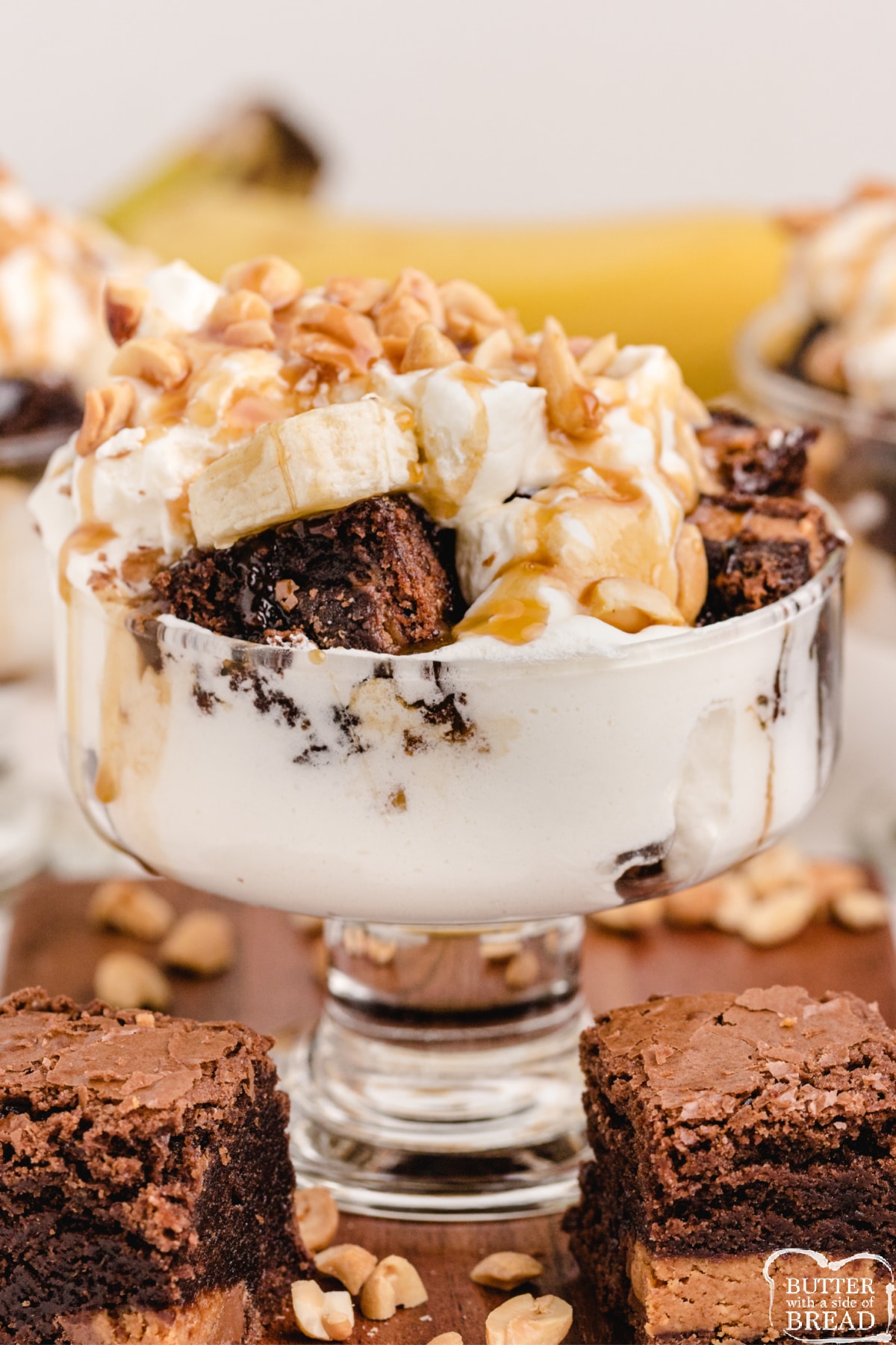 Brownie trifle made with Reese's peanut butter cups, caramel, whipped cream, bananas and chopped peanuts