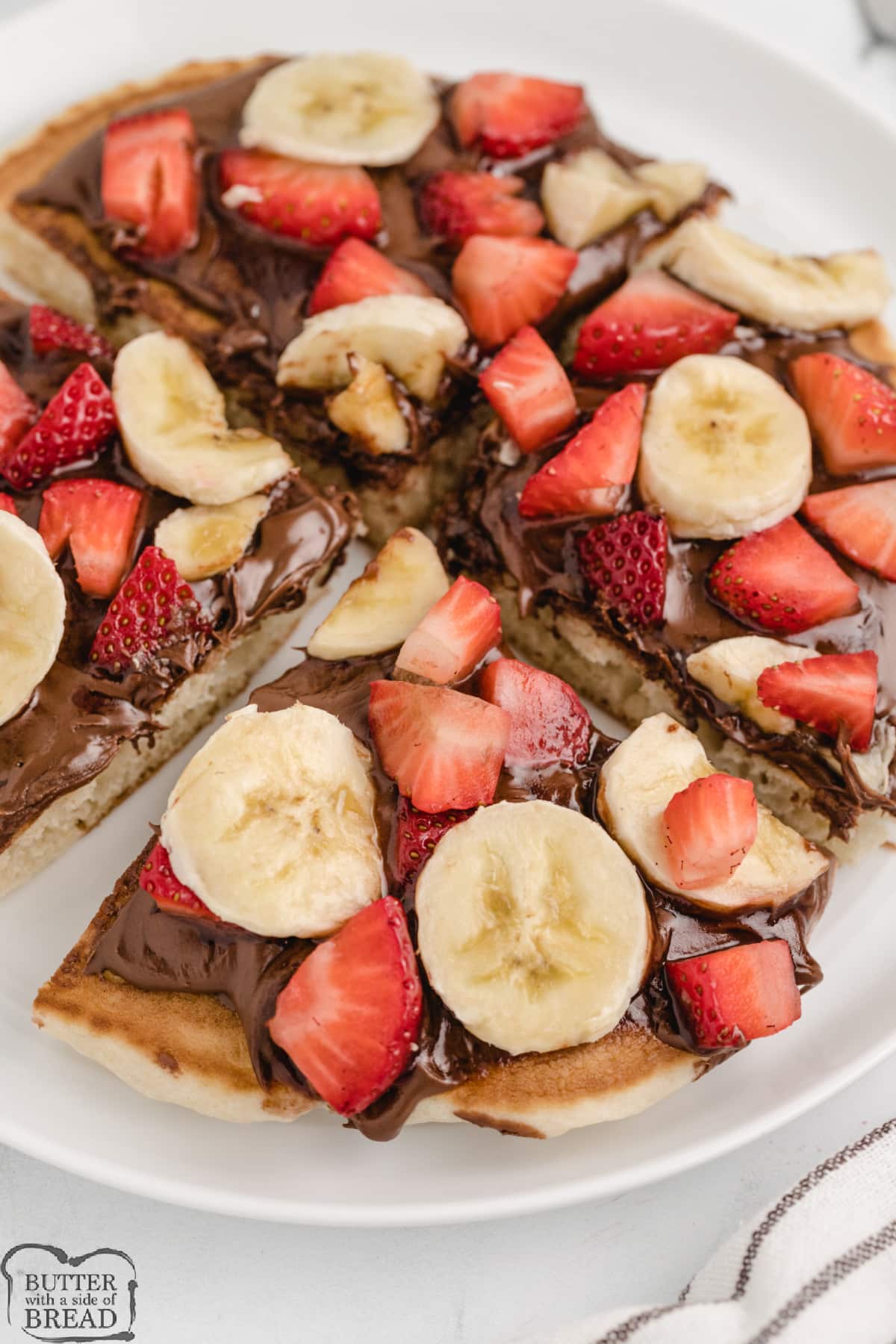 Pancake topped with nutella, strawberries and bananas