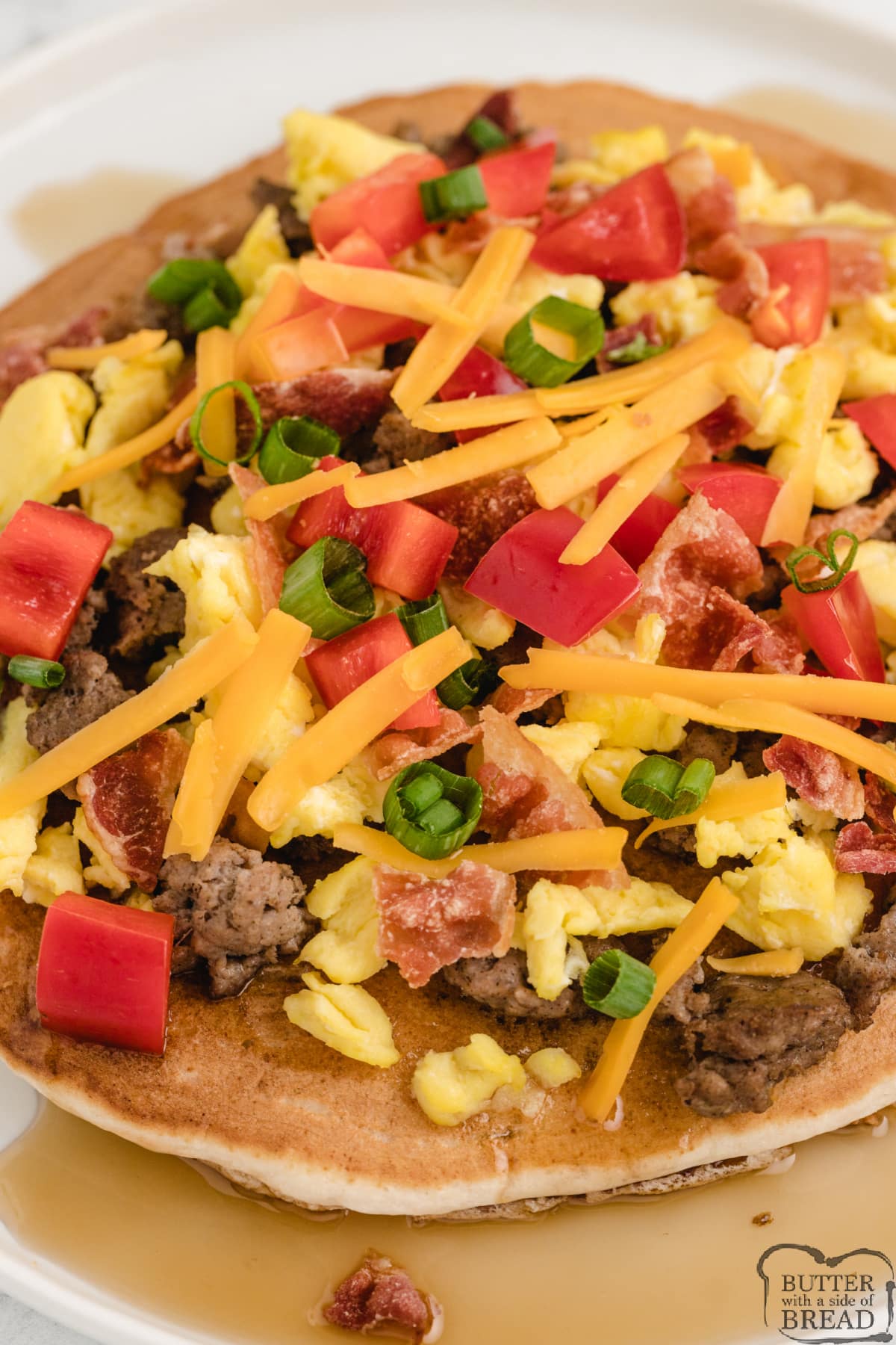 Pancake pizza topped with eggs, cheese, peppers and sausage