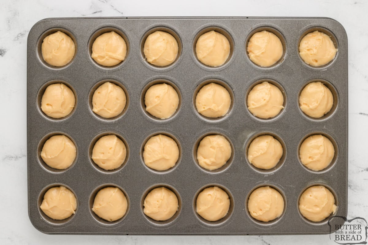 Filling mini muffin tin with cake batter. 