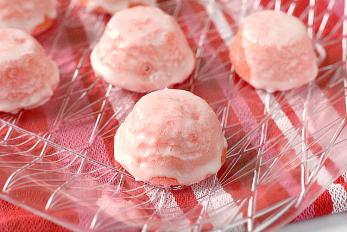 Glazed Mini Strawberry Cupcakes are delicious bite-sized treats that start with a strawberry cake mix. These mini cupcakes are dipped in a simple strawberry glaze to create a strawberries and cream flavor in an easy strawberry cake mix recipe!