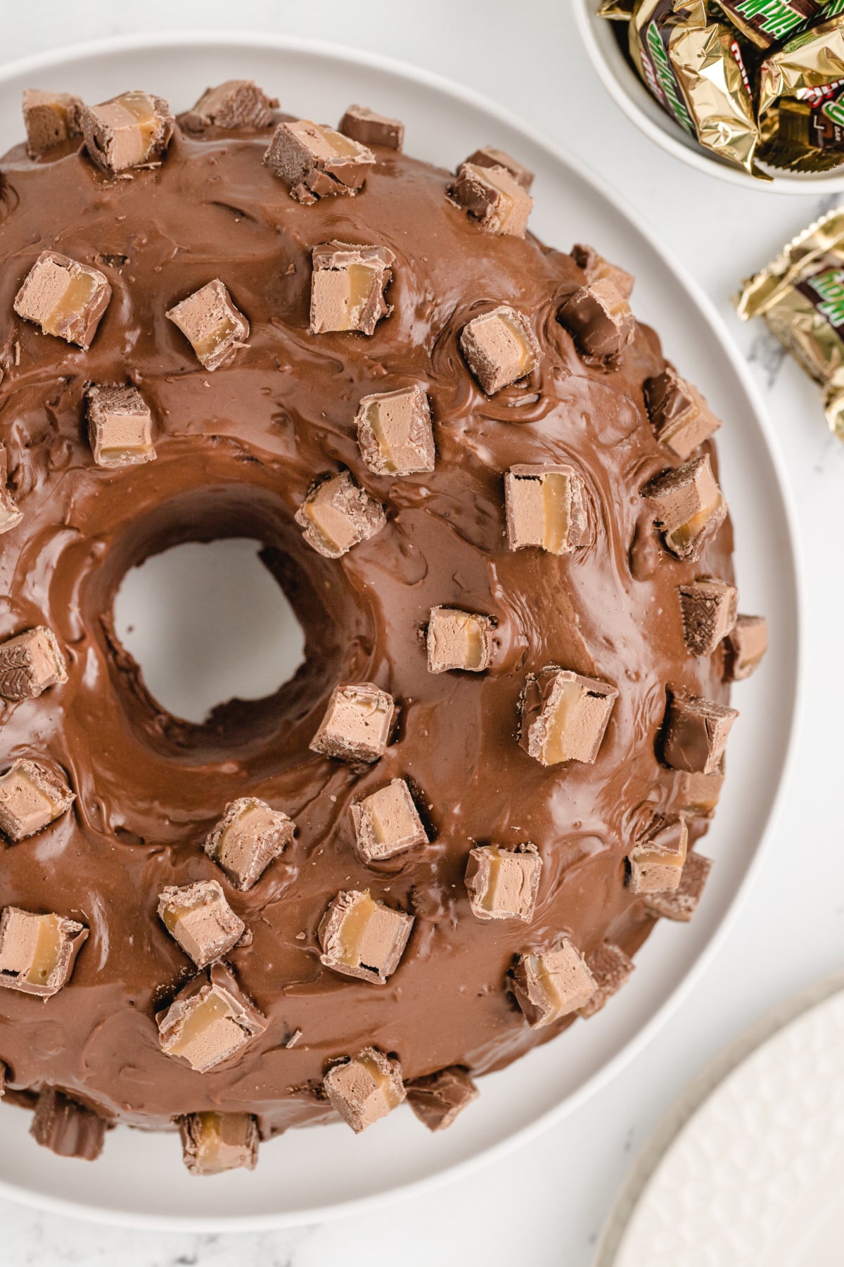 Milky Way Cake is made with melted Milky Way candy bars and topped with a chocolate marshmallow ganache! Perfect bundt cake recipe for leftover Halloween candy, holidays, or any time you need a delicious dessert recipe.