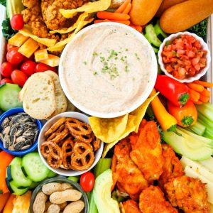 Smoky Homemade Ranch Dip served with all your game day favorites: hot wings, chicken strips & more! Wow the crowd with this savory game day snack tray that’s delicious & easy to put together.
