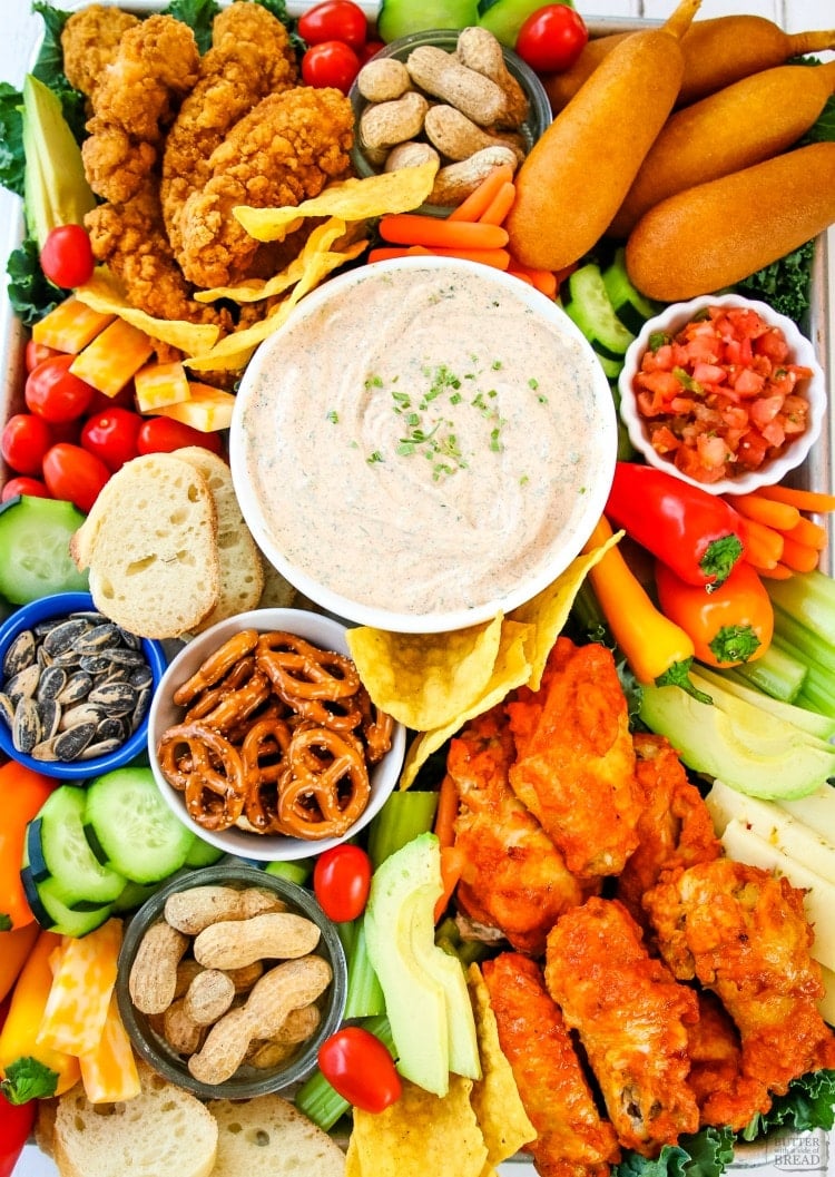 Smoky Homemade Ranch Dip served with all your game day favorites: hot wings, chicken strips & more! Wow the crowd with this savory game day snack tray that’s delicious & easy to put together.