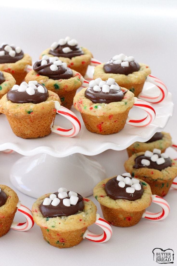Hot Chocolate Cookie Cups are the most fun & festive Christmas cookies ever! Sugar cookie cups filled with fudge, mini marshmallows & sprinkles with a darling candy cane handle!