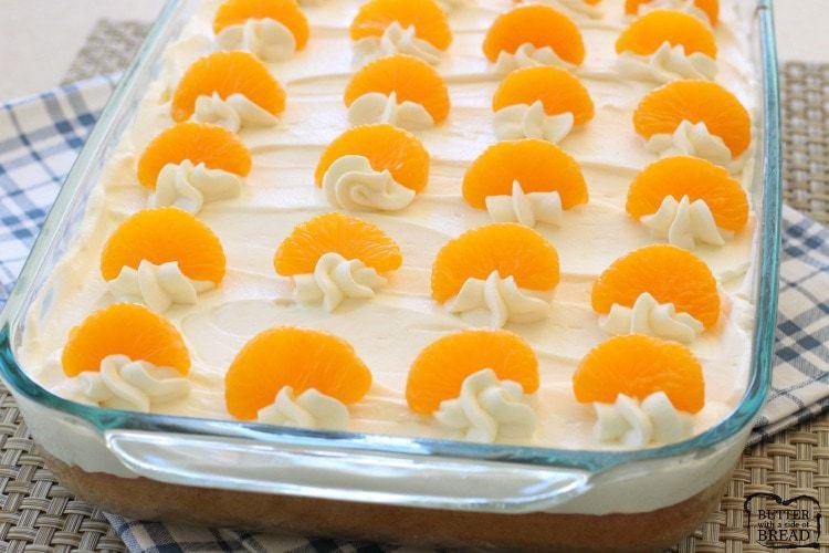 Simple & Easy Orange Chiffon Cake made in a 9x13 pan topped with stabilized citrus cream and sliced oranges