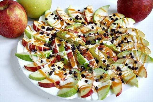 Caramel Apple Nachos are easily made by topping sliced apples with caramel, melted marshmallows, chocolate chips and sprinkles!