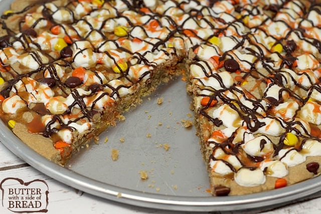 Halloween Peanut Butter Cookie Pizza is topped with marshmallows and Reese's Pieces and then drizzled with chocolate, caramel and orange icing! 