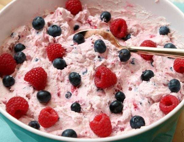 Berries and Cream Salad made using just 4 ingredients! Raspberries & Blueberries combine with Greek Yogurt, pudding mix and whipped topping to create a lovely berries and cream salad.