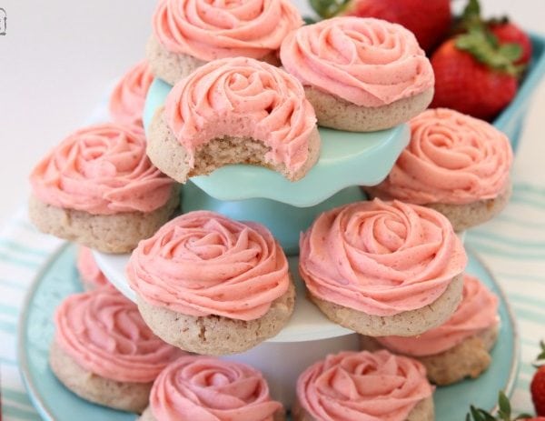 Frosted Strawberry Cookies made by adding fresh strawberries to a simple sugar cookie dough. No rolling out or chilling necessary! Just bake and top with my amazing strawberry buttercream frosting. Easy Strawberry Cookies piped with a super simple pink rose, so they taste incredible and they’re pretty too!