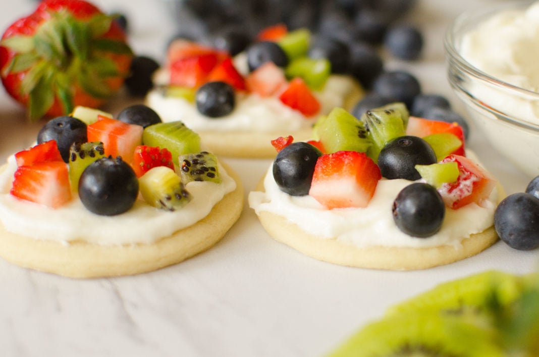 Fruit Pizza Cookies are all the goodness you get in a fruit pizza individualized! Soft crust, vanilla whipped cream frosting, topped with your favorite fruits; strawberries, raspberries, blueberries, kiwi, blackberries mango.. the possibilities are endless!Â 