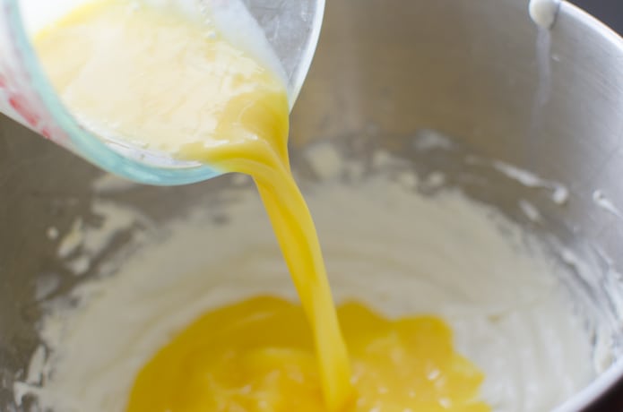 Eggs that have been whisked are added to the cheesecake batter.