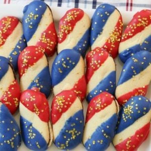 Super Simple 4th of July Cookies made with just 4 ingredients and NO BAKE! Easy red, white and blue cookies made with Milano cookies dipped in red and blue melting chocolate then sprinkled with gold stars. Made in just 15 minutes and they’re perfectly patriotic!