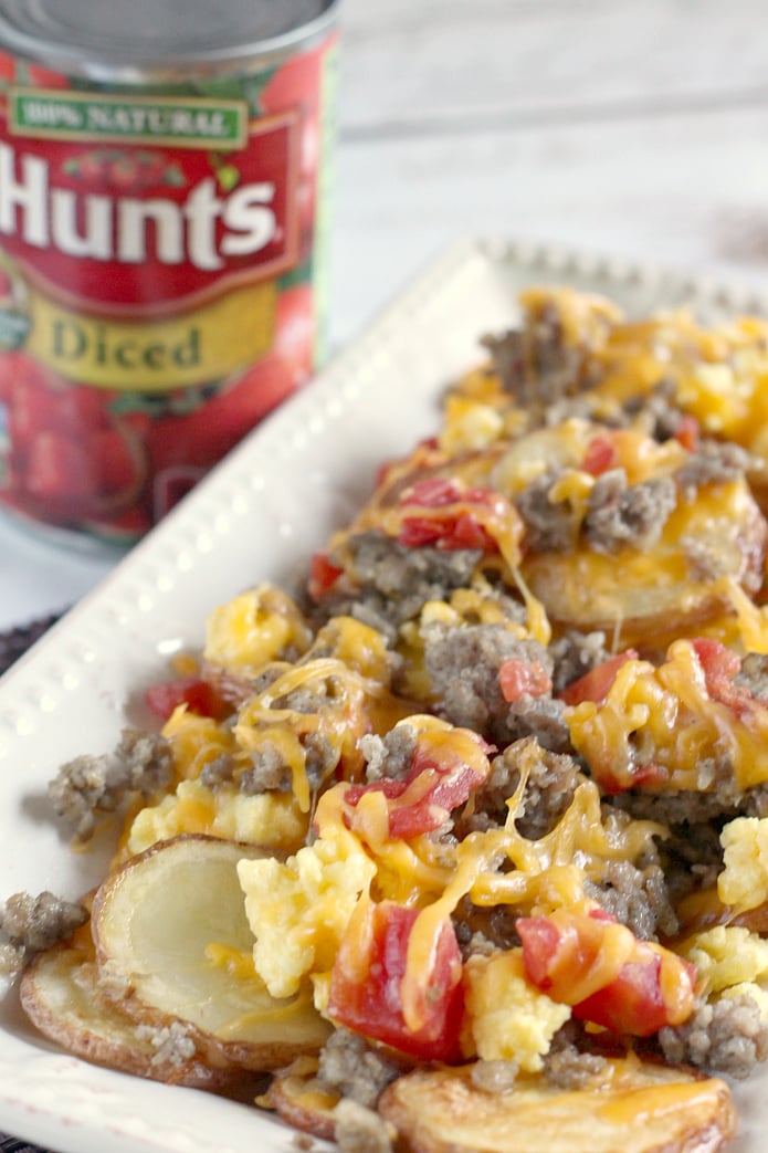Easy Breakfast Nachos are made with sliced potatoes, sausage, cheese, scrambled eggs and Hunt's Diced Tomatoes.