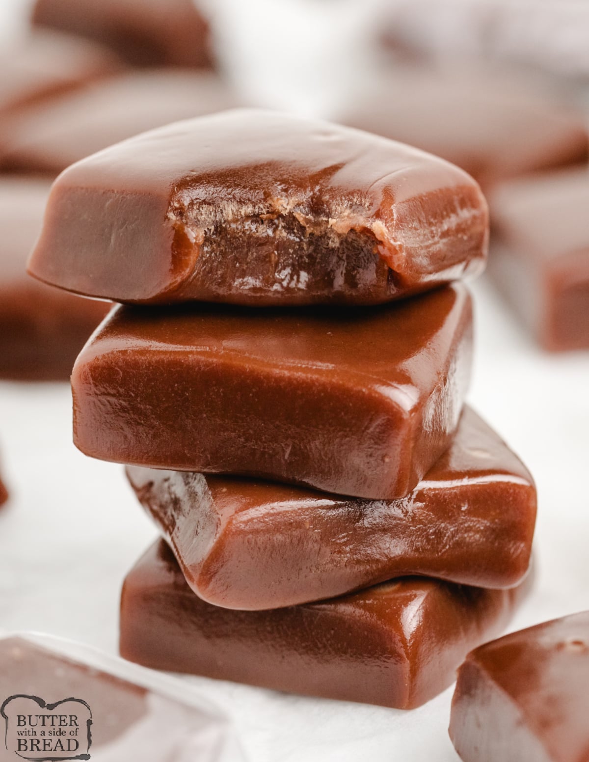 Stack of homemade chocolate caramels showing soft, chewy texture.