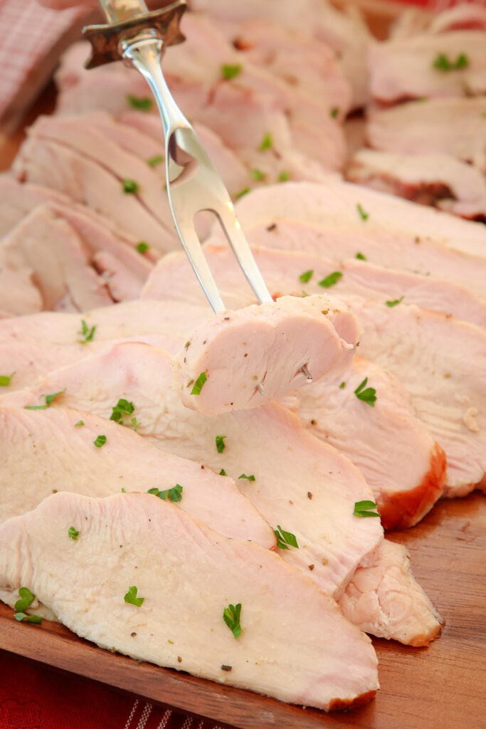 meat fork with a piece of smoked turkey on a platter