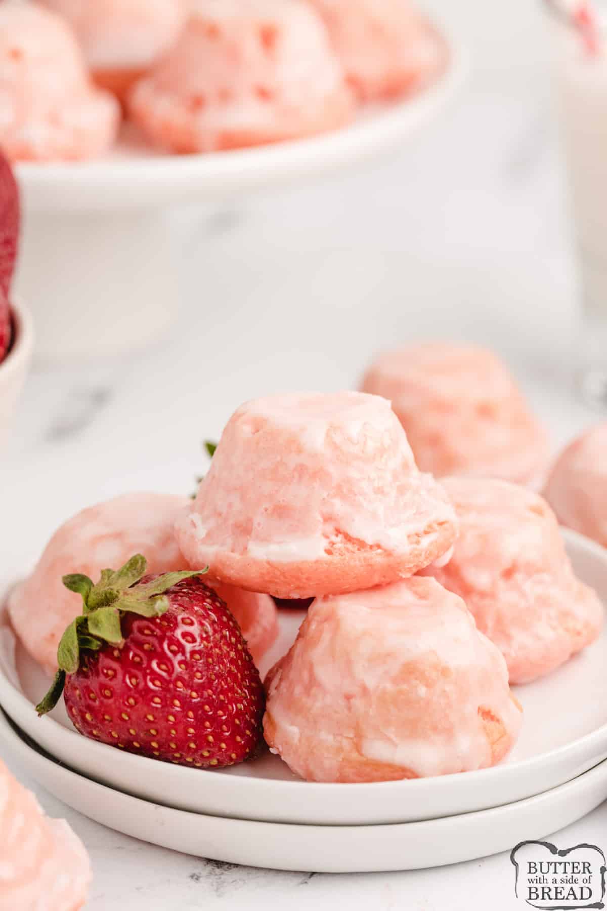 Glazed Mini Strawberry Cupcakes are delicious bite-sized treats that start with a strawberry cake mix. The easy strawberry glaze soaks into the bottoms to make these little cupcakes even more incredible.