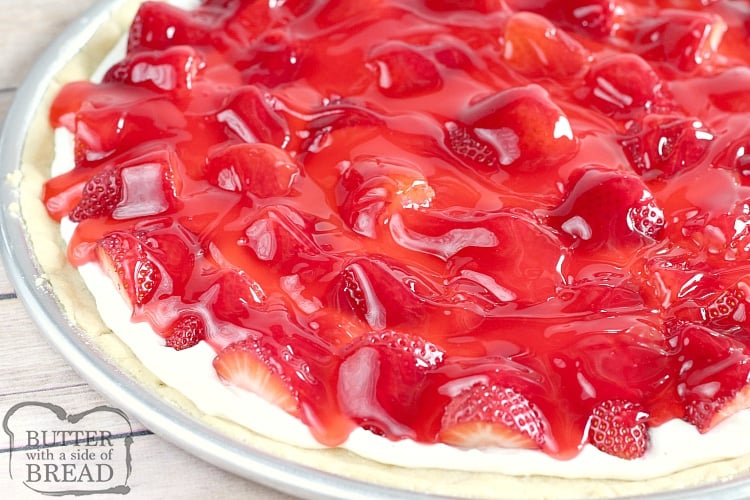 Glazed Strawberry Fruit Pizza is made with a sugar cookie crust that is topped with a cream cheese layer, fresh strawberries and a delicious strawberry glaze! This fruit pizza recipe is so easy to make by using pre-made sugar cookie dough and the glaze is made with strawberry jello and a few other basic ingredients.