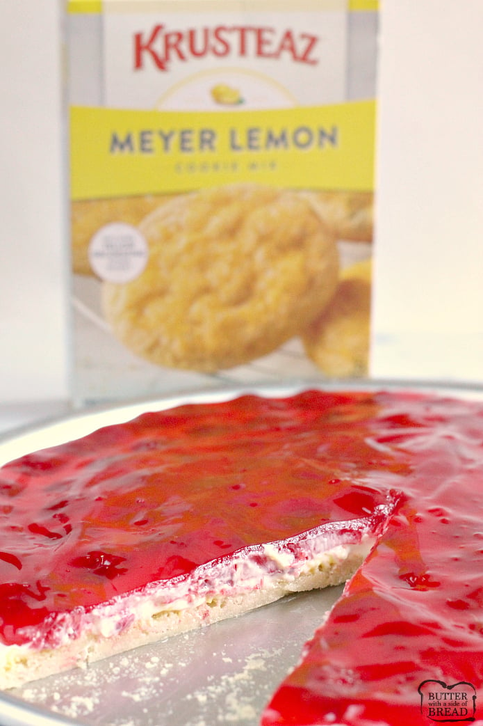 Lemon Raspberry Fruit Pizza is made with a lemon sugar cookie crust that is topped with a cream cheese layer, fresh raspberries and a delicious raspberry glaze! This fruit pizza recipe is so easy to make by using a lemon cookie mix and the glaze is made with raspberry jello!