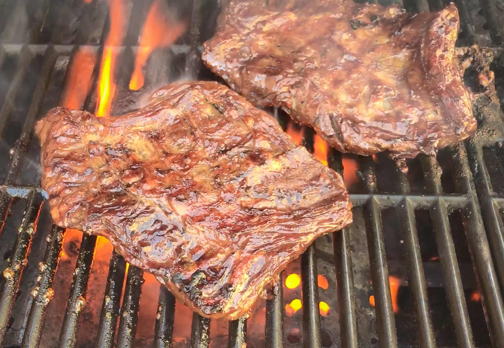 marinated steak on a grill with flames