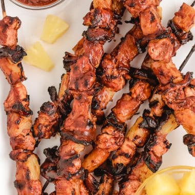 making chicken kabobs with BBQ sauce, pineapple and bacon