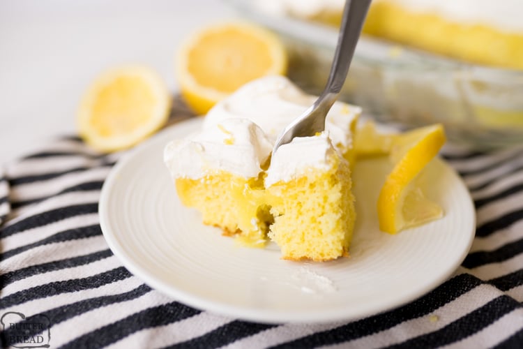 Lemon Poke cake, plated and being eaten with a fork.