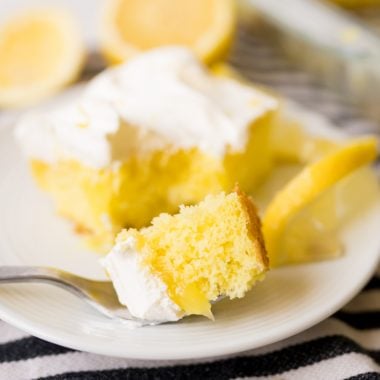 Lemon poke cake with lemon pie filling, plated, with some cake on the fork.