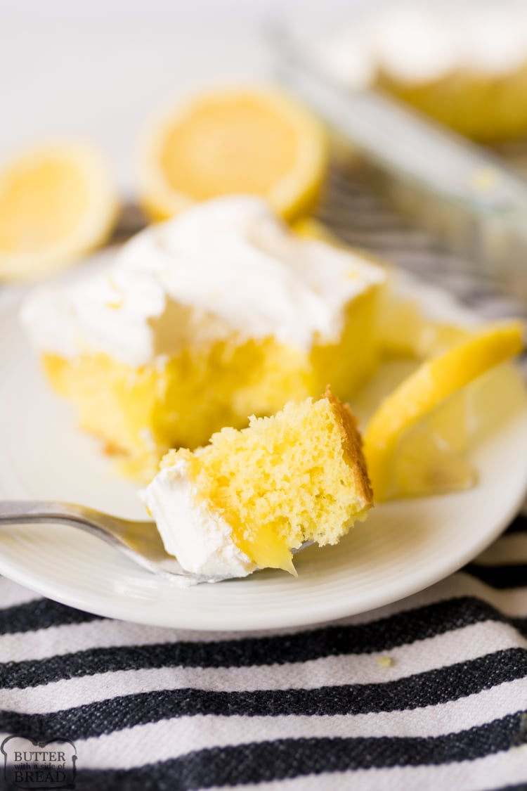 Lemon poke cake with lemon pie filling, plated, with some cake on the fork. 
