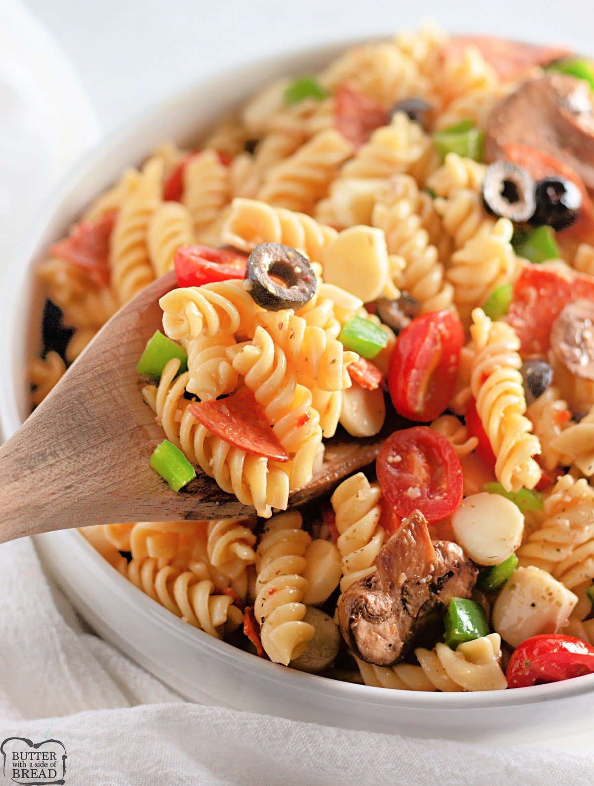 Cold pasta salad recipe with pepperoni, mozzarella, olives and other pizza toppings