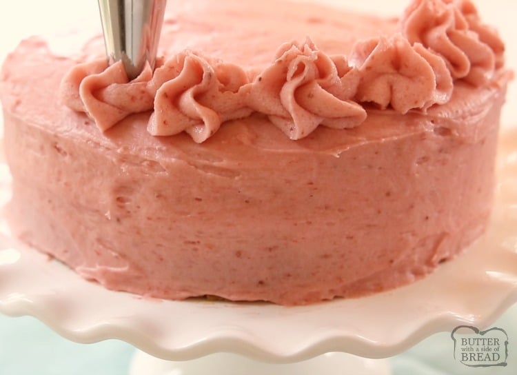 frosting a cake with strawberry frosting