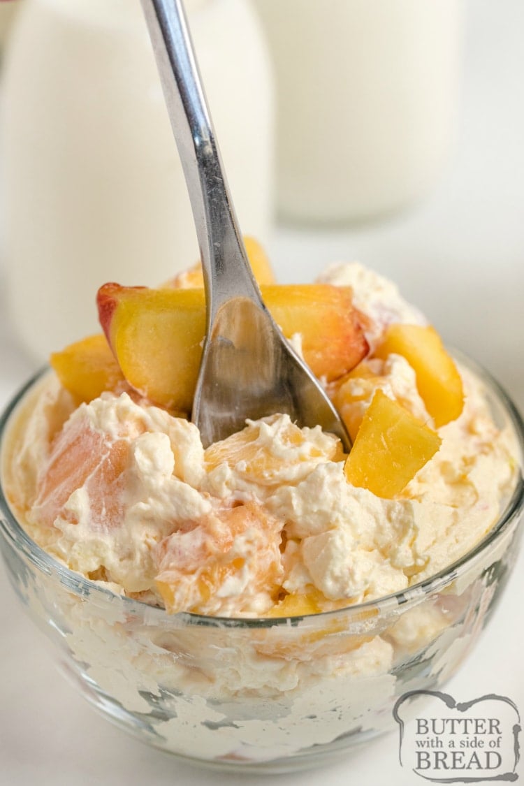 Bowl of fruit salad with cream topping and fresh peaches