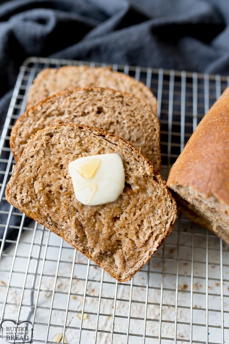 honey wheat bread, sliced with butter on it