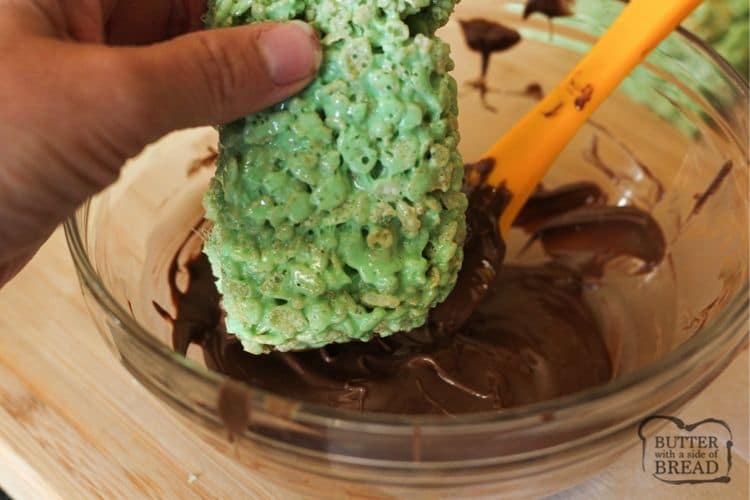 dipping green rice krispies into melted chocolate