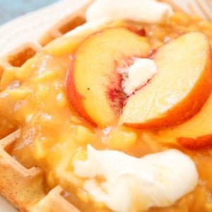 Peaches and Cream Waffles made with a crispy Belgian waffle recipe topped with a simple homemade chunky peach syrup and sweet cream. Perfect waffle recipe for special occasions and brunch!