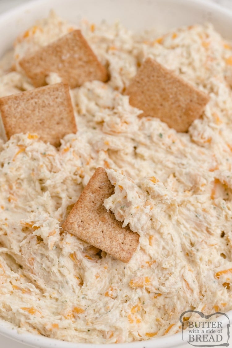 Dipping wheat thins in ranch dip with chicken and cheese