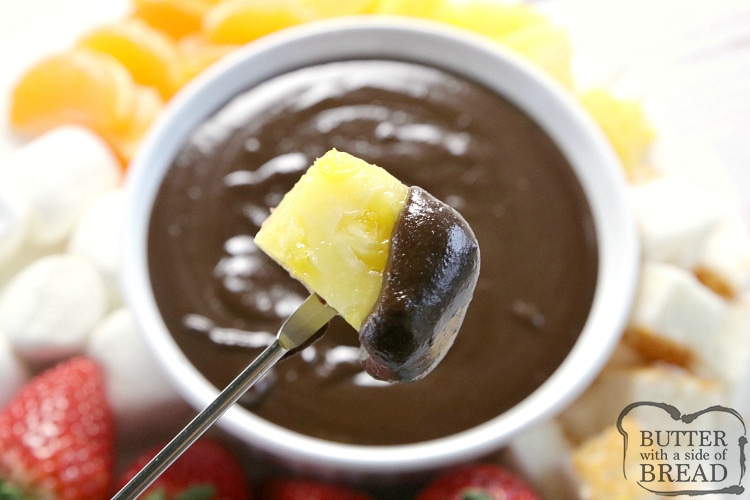 Dipping pineapple into chocolate
