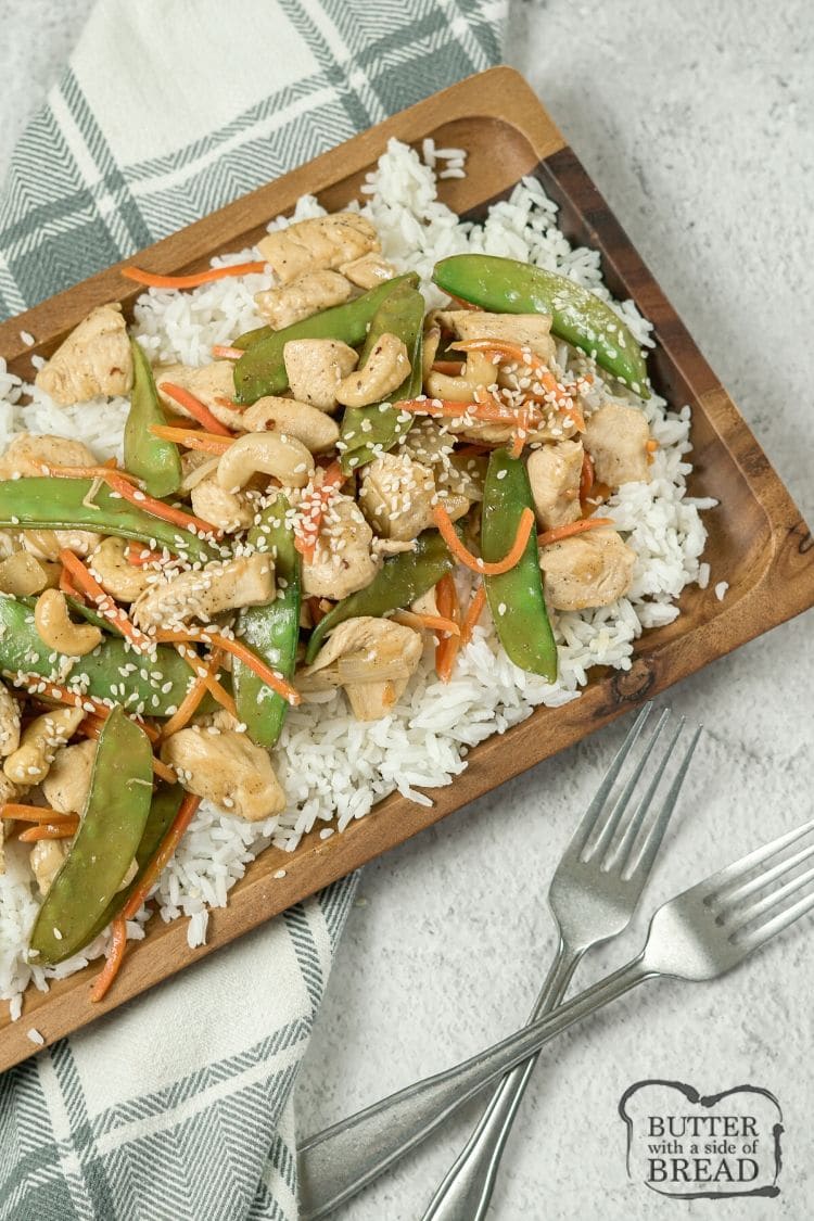 cashew chicken over rice on a wooden platter