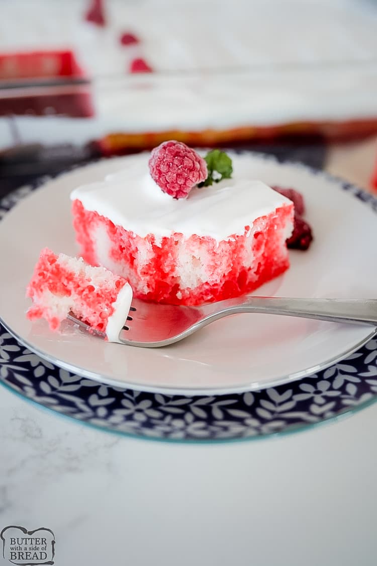 Raspberry Jello Poke Cake is a simple yet flavorful cake recipe. White cake infused with raspberry jello topped with cream to make one memorable, easy poke cake!