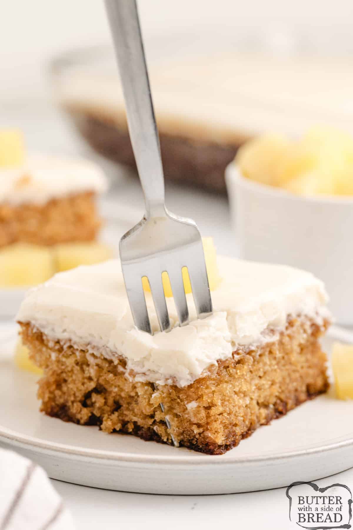 Bite of pineapple cake with cream cheese frosting.