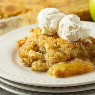 Easy Apple Dump Cake recipe with just 4 simple pantry ingredients! Cake mix & apple pie filling transform into a delicious apple dessert perfect for any occasion.