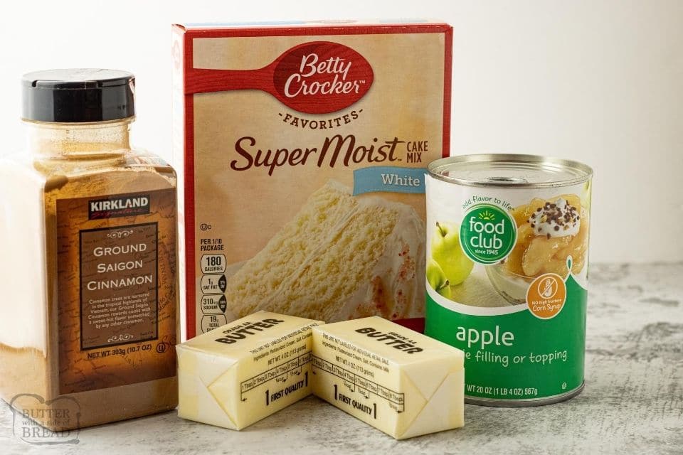ingredients for dump cake, cinnamon, butter, apple pie filling and cake mix